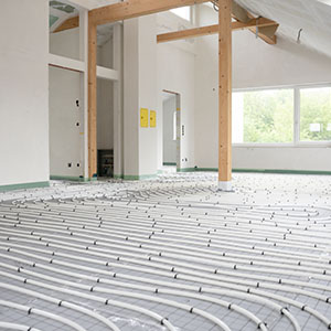 a house in the middle of renovation with underfloor pipes laid out on an exposed floor