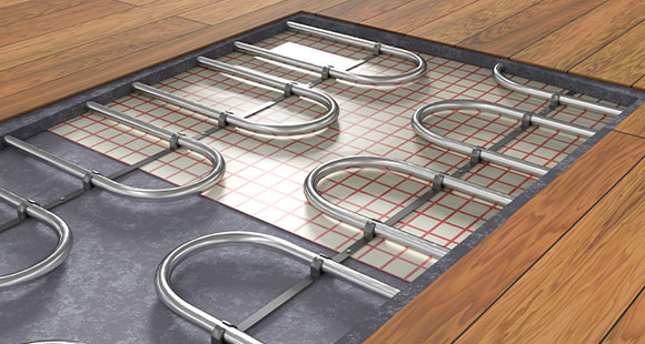 an exposed section of a laminate floor showing the metal underfloor heating pipes underneath